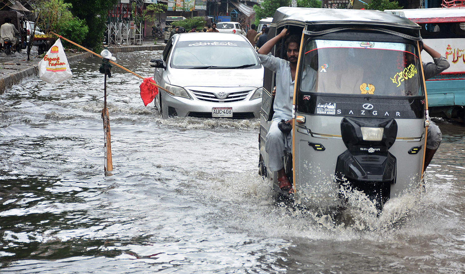 Commuters drive through a flooded street after heavy monsoon rains in Hyderabad, Sindh province on August 29, 2024. (AFP)