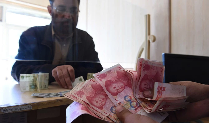 In this file photo, taken on January 3, 2018, a Pakistani currency dealer counts Chinese currency for his customer at his shop in Quetta. (AFP/File)