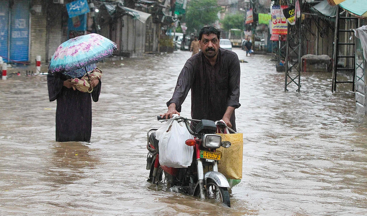A man wades through a flooded street during heavy rainfall in Lahore on August 1, 2024. (AFP)