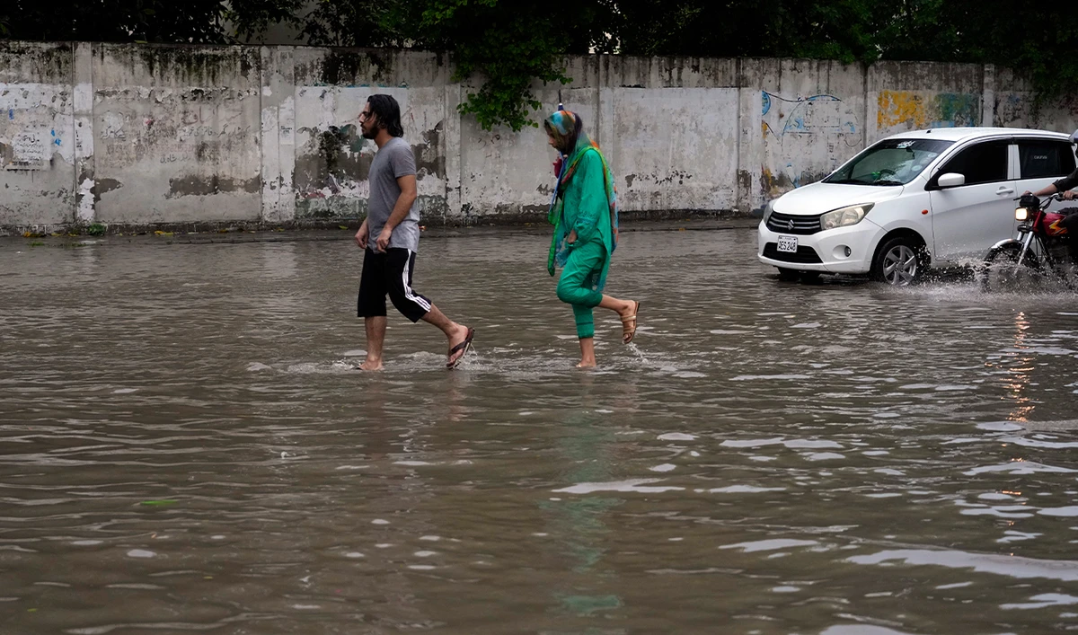 People walk through a flooded road caused by heavy monsoon rainfall in Lahore, Pakistan, on August 11, 2024. (AP/File)