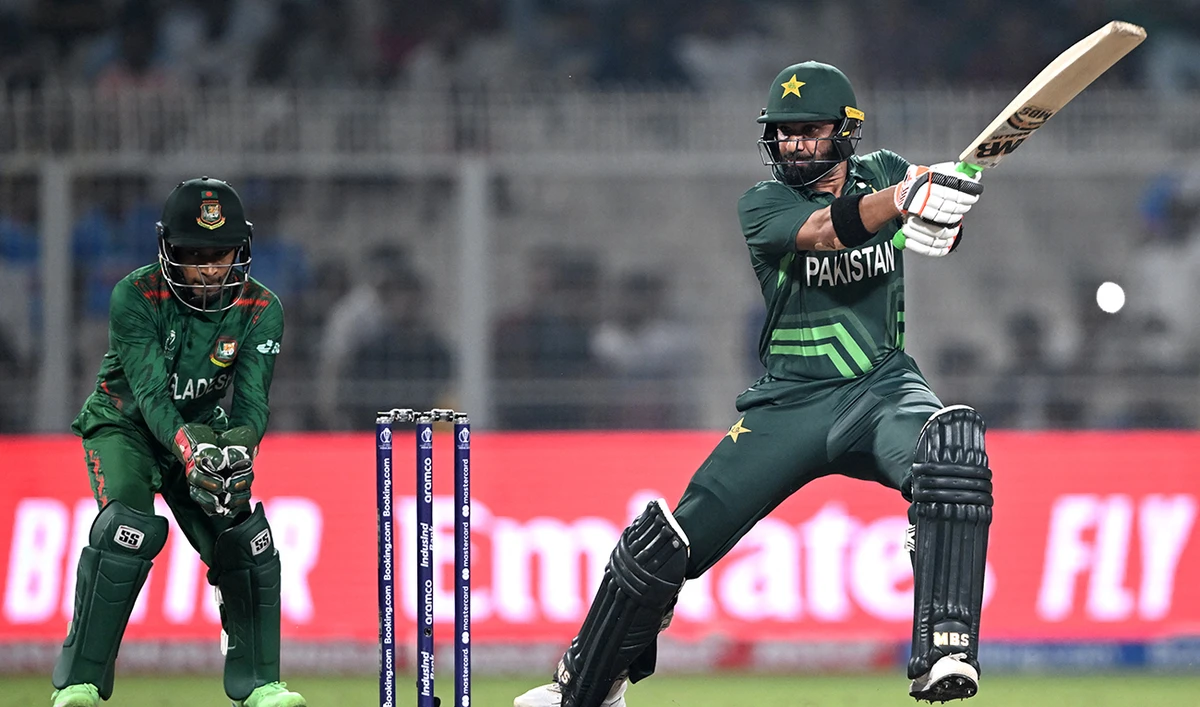 Pakistan's Iftikhar Ahmed (R) plays a shot as Bangladesh's wicketkeeper Mushfiqur Rahim watches during the 2023 ICC Men's Cricket World Cup one-day international (ODI) match between Pakistan and Bangladesh at the Eden Gardens in Kolkata on October 31, 2023. (AFP/File)