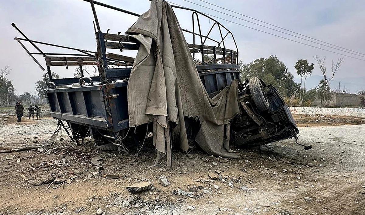 Paramilitary soldiers stand guard in front of the wreckage of a police truck at the site of a roadside bomb blast in Bajaur district, around 14 kms from the border with Afghanistan on January 8, 2024. (AFP/File)