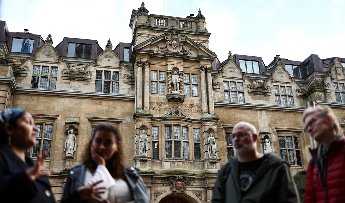 Tour guide Devika talks with a group of people attending Oxford tour outside the Rhodes Building, in Oxford, on October 20, 2023. (AFP/File)