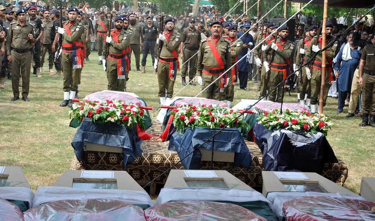 A police contingent present honor guard to police officers, who were killed in the gunmen ambushed on a police convoy in a deserted area, during a funeral prayer, in Rahim Yar Khan, Pakistan, Friday, Aug. 23, 2024. (AP)