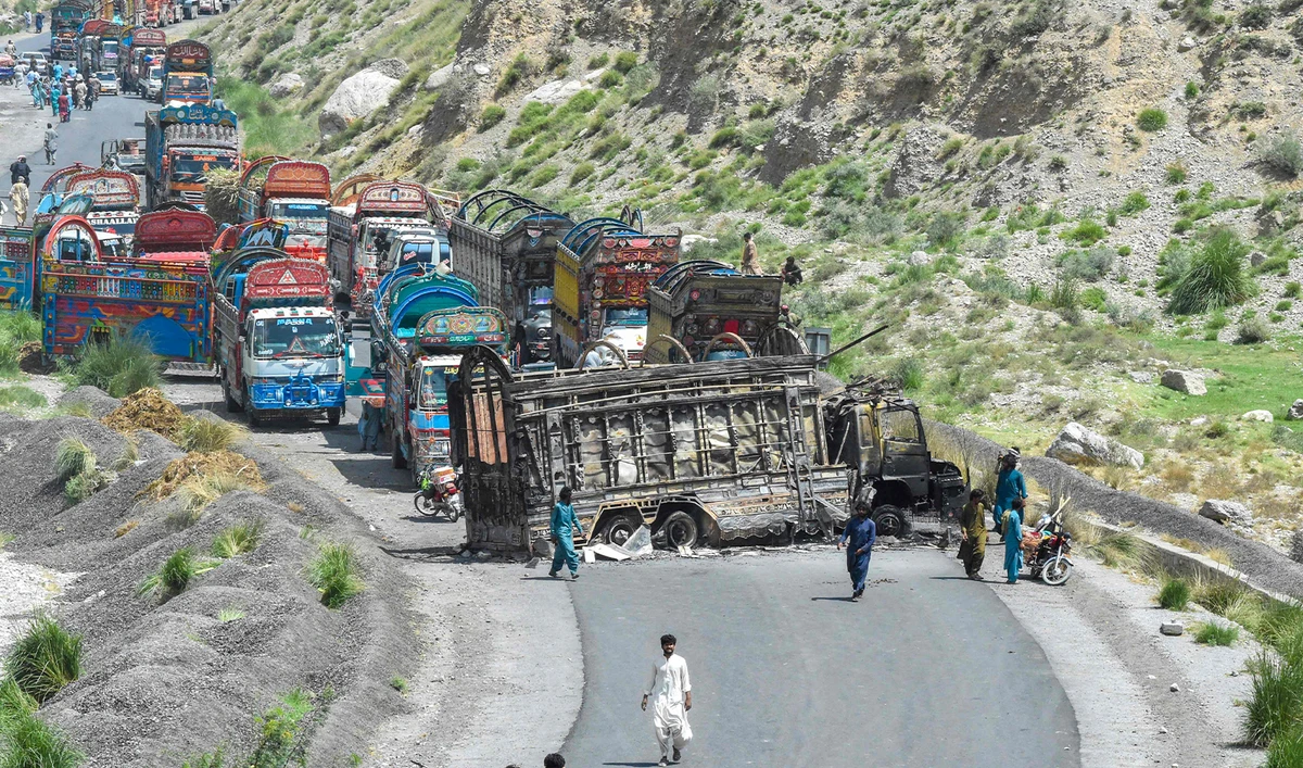 People look at a charred vehicle near a collapsed railway bridge a day after a blast by separatist militants at Kolpur in Bolan district, Balochistan province on August 27, 2024. (AFP)