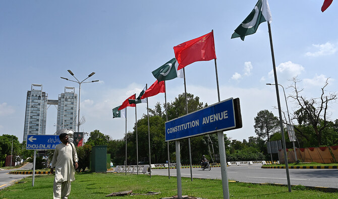 A man walks past China's and Pakistani national flags installed on the constitution avenue ahead of the visit of Chinese Vice Premier He Lifeng, in Islamabad on July 30, 2023. (AFP/File)
