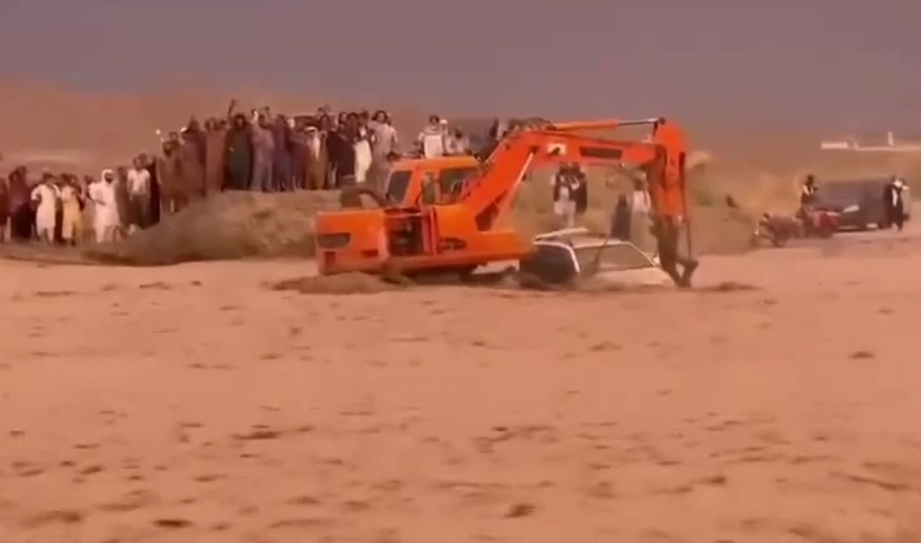 This undated photo shows an excavator rescuing a white jeep stranded in a flash flood in Qilla Abdullah, Balochistan. (Photo courtesy: Facebook/@ attock.official)