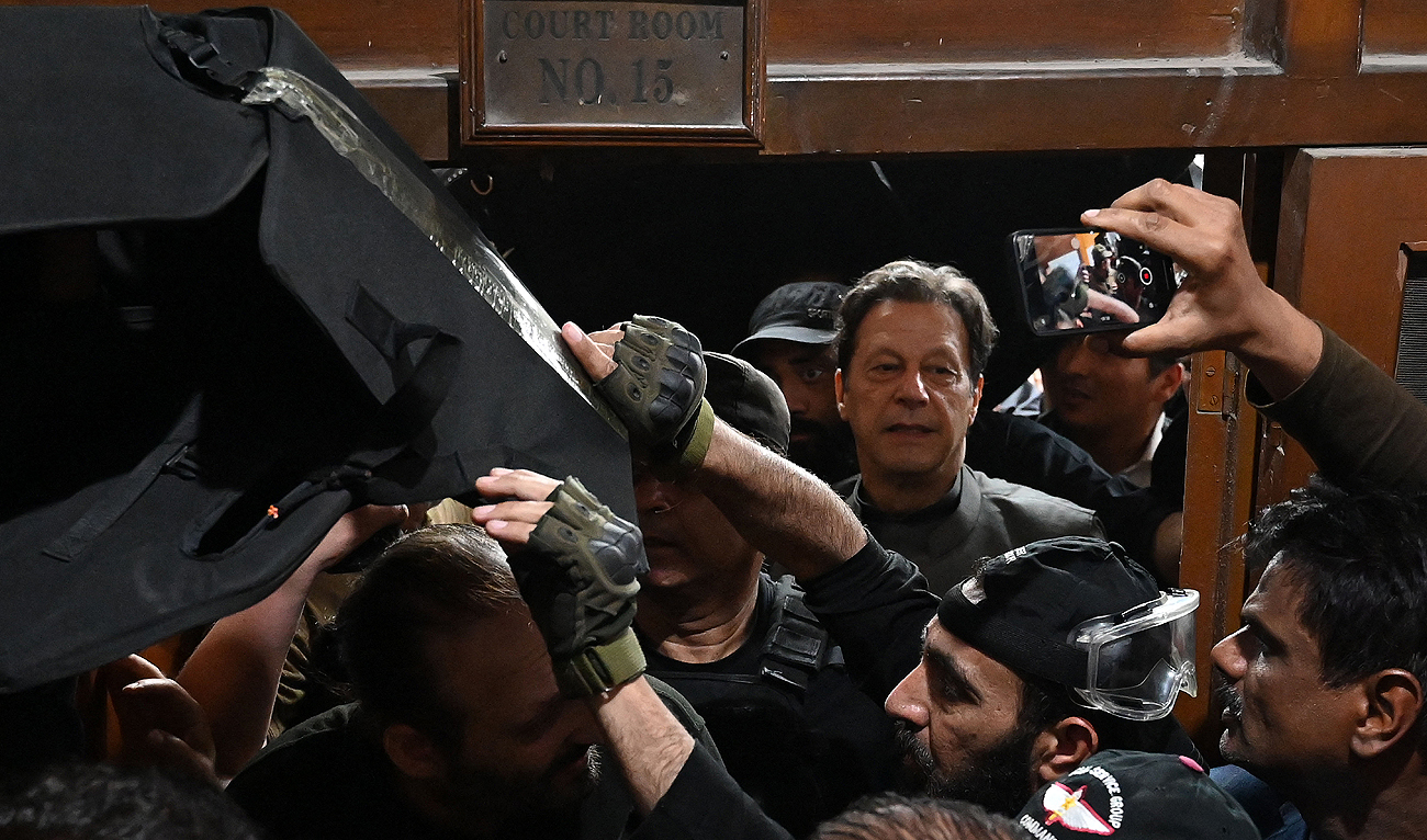 Pakistan’s former prime minister Imran Khan (C) leaves after appearing before a court for a protective bail in relation to two cases, in Lahore on March 21, 2023. (AFP/File)