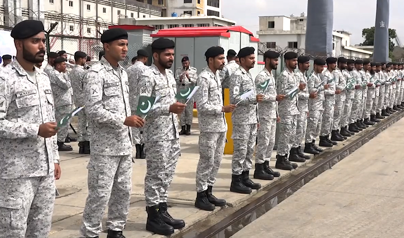 In this handout photograph, taken and released by Pakistan Navy on August 30, 2024, Pakistan Navy personnel hold national flags as PNS Hunain arrives at Karachi port in Karachi. (Photo courtesy: Pakistan Navy/File)