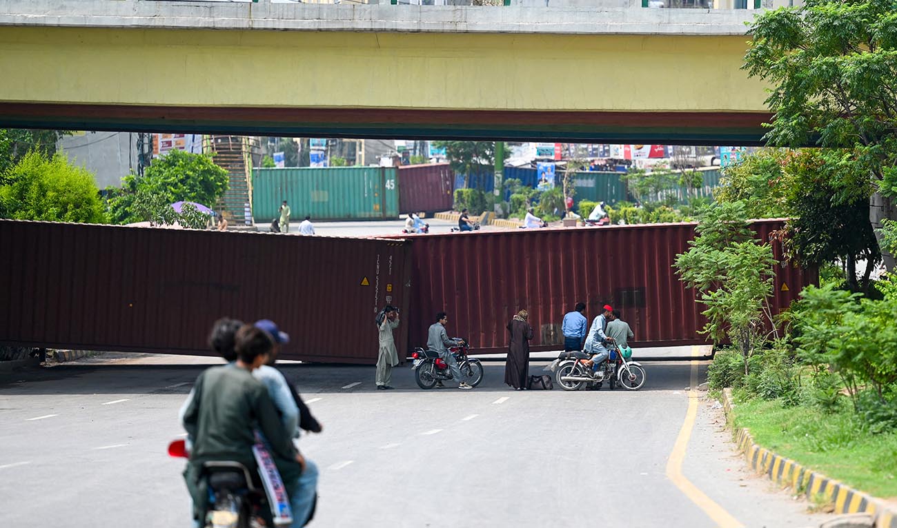 Police block a street with shipping containers ahead of a political party protest in Islamabad on July 26, 2024. (AFP/File)
