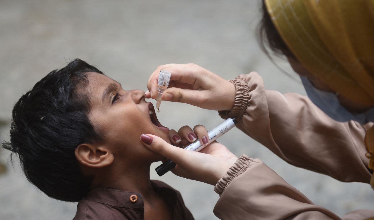 A health worker administers polio drops to a child during a door-to-door vaccination campaign in Karachi on August 7, 2023. (AFP/File)