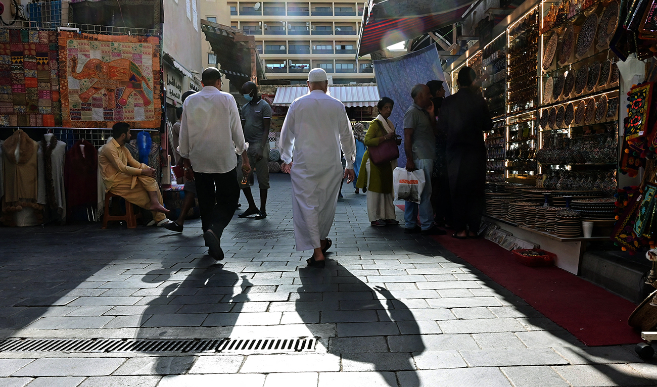 A picture taken on March 15, 2020 shows people walking past shops in Dubai's Deira Souk. (AFP/File)