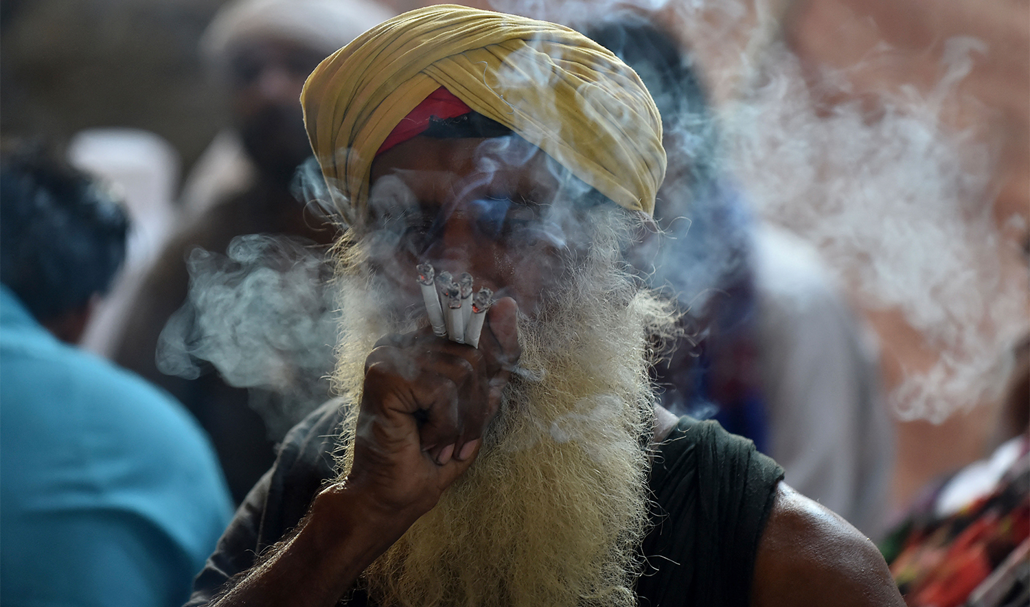 A Sufi devotee smokes at the Data Darbar Shrine during the three-day annual 'Urs' religious festival in Lahore on October 6, 2020. The Data Darbar complex contains the shrine of Saint Syed Ali bin Osman Al-Hajvery, popularly known as Data Ganj Bakhsh. (AFP/File)