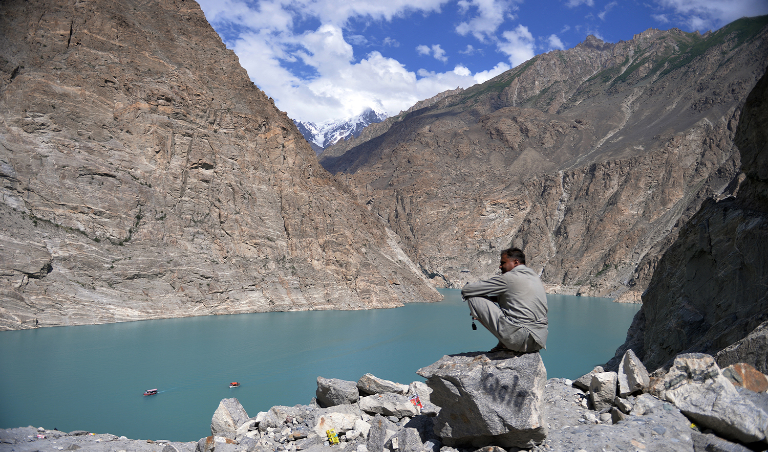 In this photograph taken on August 3, 2014 a visitor watches the boats arriving on the banks of the Attabad lake in the northern Hunza valley. (AFP/File)
