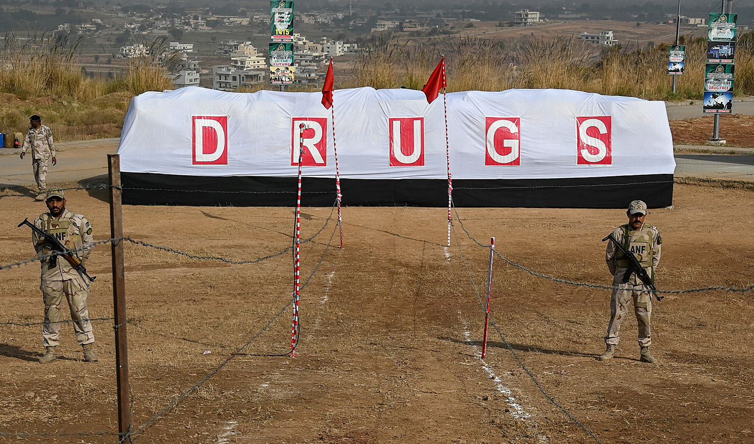 Soldiers of Anti-Narcotic Force (ANF) stand guard beside a pile of seized drugs before setting it on fire on the outskirts of Islamabad on November 24, 2021 as Pakistani authorities torched tonnes of seized drugs, including heroin, hashish, cocaine, and opium at a ceremony attended by diplomats and anti-narcotics officials. (AFP/File)