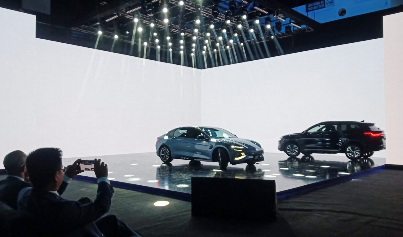 An attendee takes photos of the Chinese electric vehicle BYD models on display, during an event to announce the plans to open a car production plant in Pakistan, in Lahore on August 17, 2024. (REUTERS)