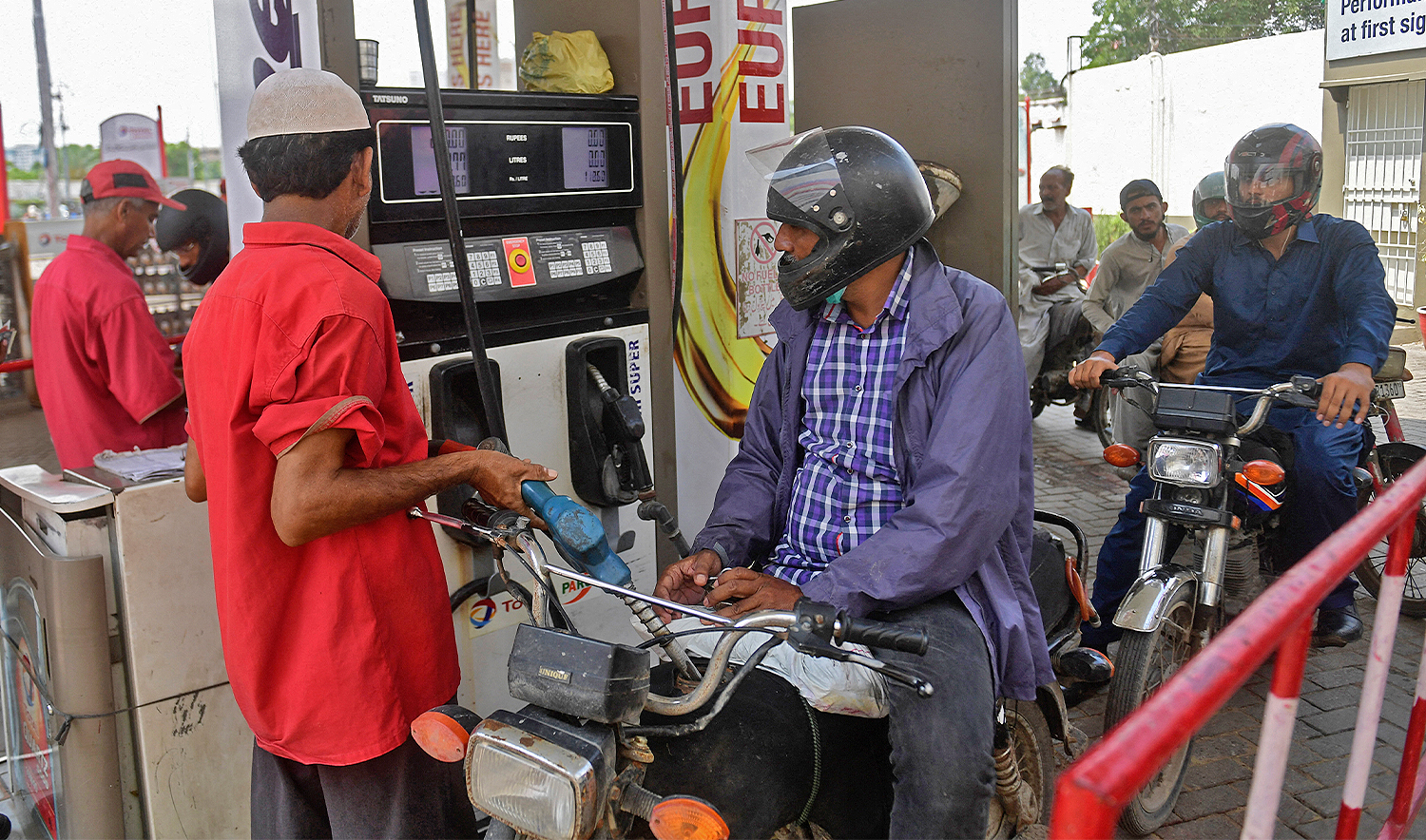 An employee of a gas station fills the tank of a motorbike in Karachi on July 16, 2021. (AFP/File)