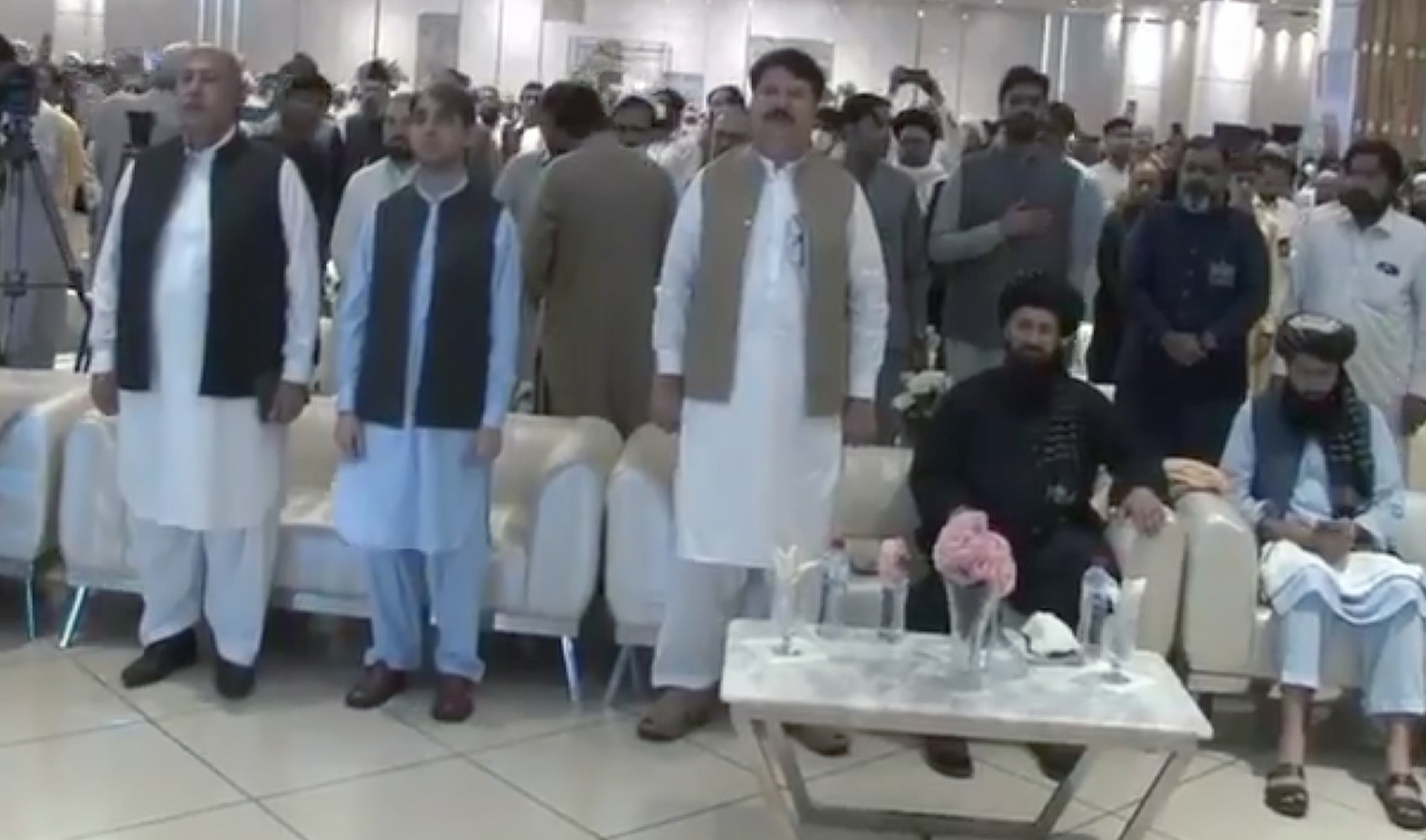 The picture was taken from a video shared by Rehmat Mehsud on X on September 17, 2024, shows the Afghan Consul General in Peshawar, Hafiz Mohibullah Shakir (second from right), sitting during Pakistani national anthem at a conference in Peshawar, Pakistan. (Rehmat Mehsud)