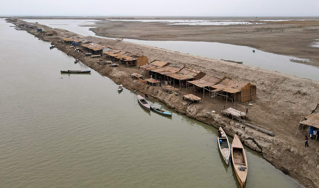 This aerial photograph taken on August 3, 2024, shows a settlement along the banks of a canal at Khan Muhammad Mallah village in Main Nara Valley, Dadu district of Sindh province. (AFP/File)