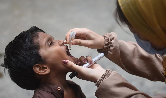 A health worker administers polio drops to a child during a door-to-door vaccination campaign in Karachi on August 7, 2023. (AFP/File)