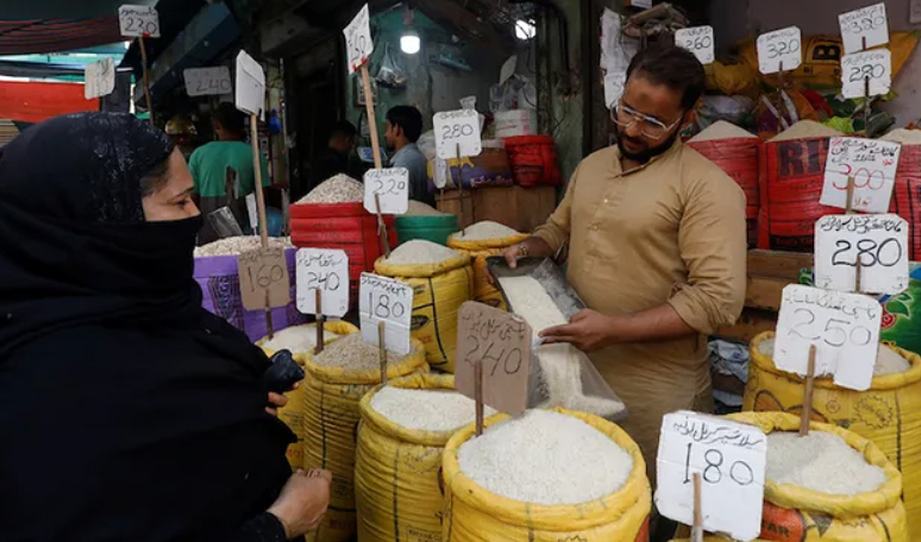 A shopkeeper fills a bag of rice for a customer, at a shop along a market in Karachi on June 9, 2023. (Reuters/File)