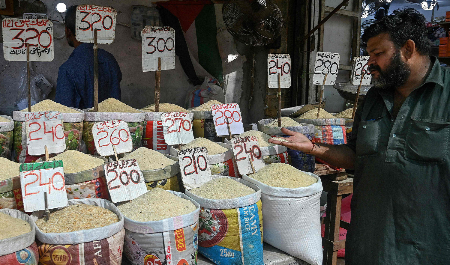 A man checks the quality of rice at a grocery shop in Karachi on September 26, 2024. (AFP)