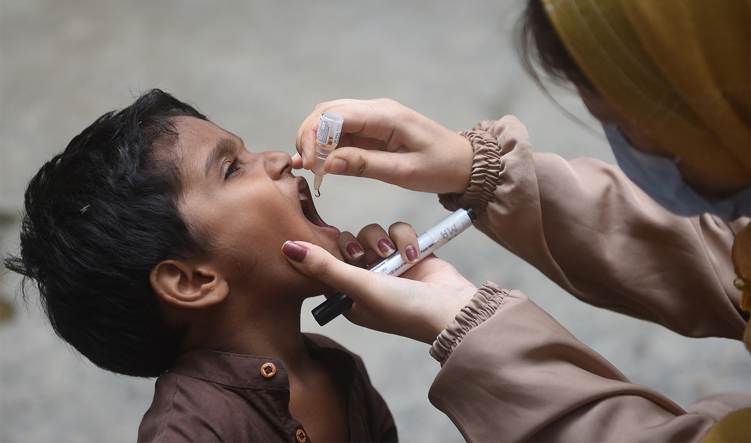 A health worker administers polio drops to a child during a door-to-door vaccination campaign in Karachi on August 7, 2023. (AFP/File)