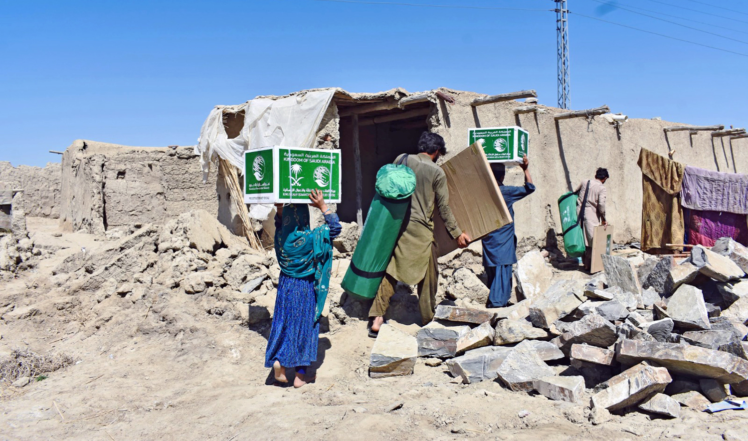 The picture shared by Saudi Arabia’s King Salman Humanitarian Aid and Relief Center (KSrelief) on September 28, 2024 shows affected families carrying relief aid in Pakistan. (KSrelief)