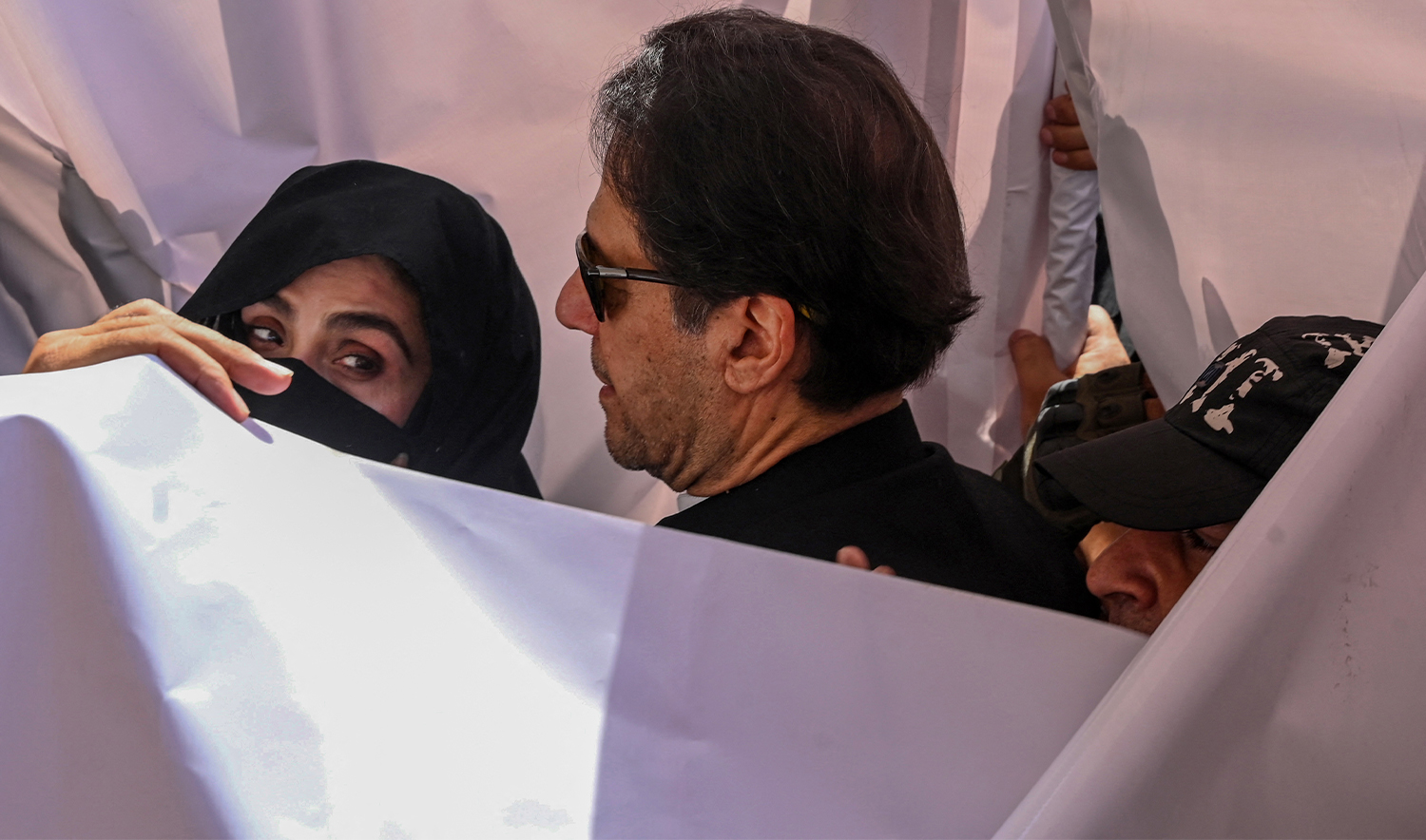 Former Pakistan Prime Minister Imran Khan (C) with his wife Bushra Bibi (L) arrive to appear at a high court in Lahore on May 15, 2023. (AFP/File)