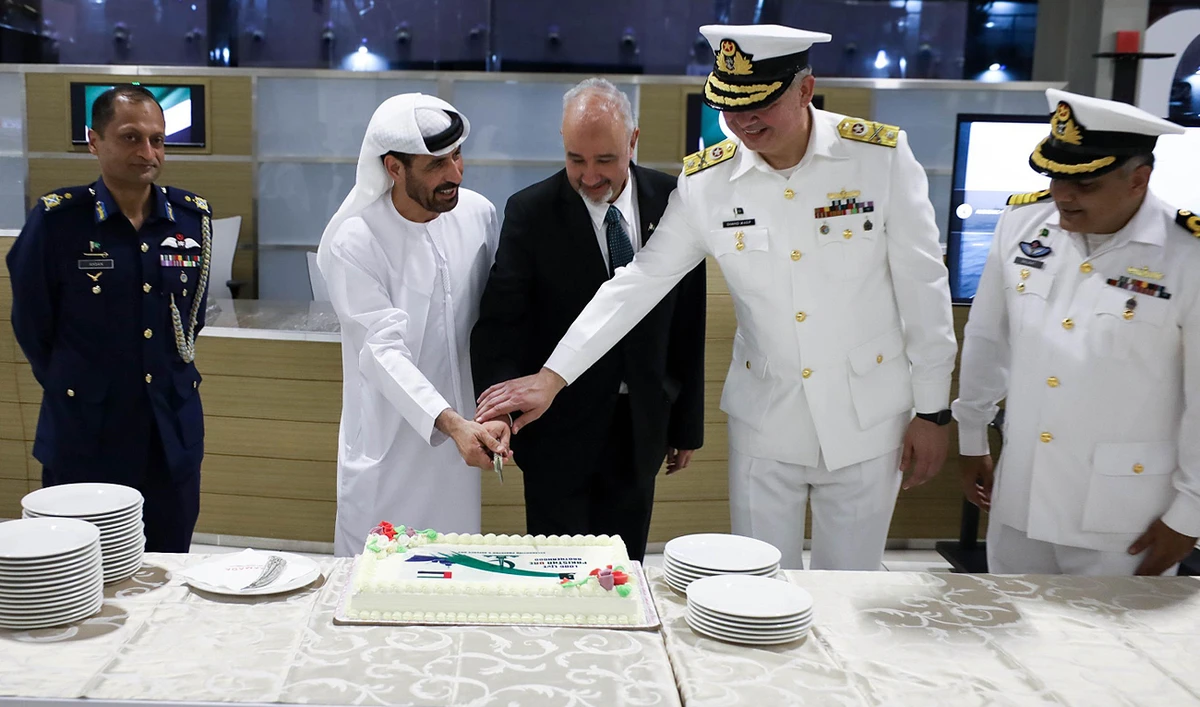 In this handout photograph, taken and released by Pakistan Embassy, Pakistan’s envoy to the UAE, Ambassador Faisal Niaz Tirmizi (C), along with Commodore Shahid Wasif SI (M) (2R), Mission Commander of the Pakistan Navy, and General Salem Saeed Al Jabri (2L), UAE’s Assistant Foreign Minister for Military and Security Affairs, gesture during a cake cutting ceremony to mark Pakistan’s Defense Day onboard Pakistan Navy Ship Shamsheer at the Cruise Terminal, Mina Zayed Port in Abu Dhabi on September 5, 2024. (Photo courtesy: Pakistan Embassy)