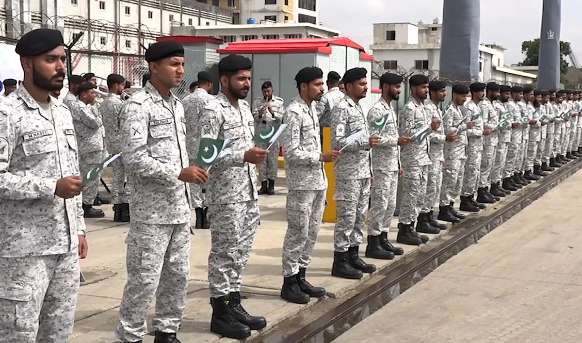 In this handout photograph, taken and released by Pakistan Navy on August 30, 2024, Pakistan Navy personnel hold national flags as PNS Hunain arrives at Karachi port in Karachi. (Photo courtesy: Pakistan Navy/File)