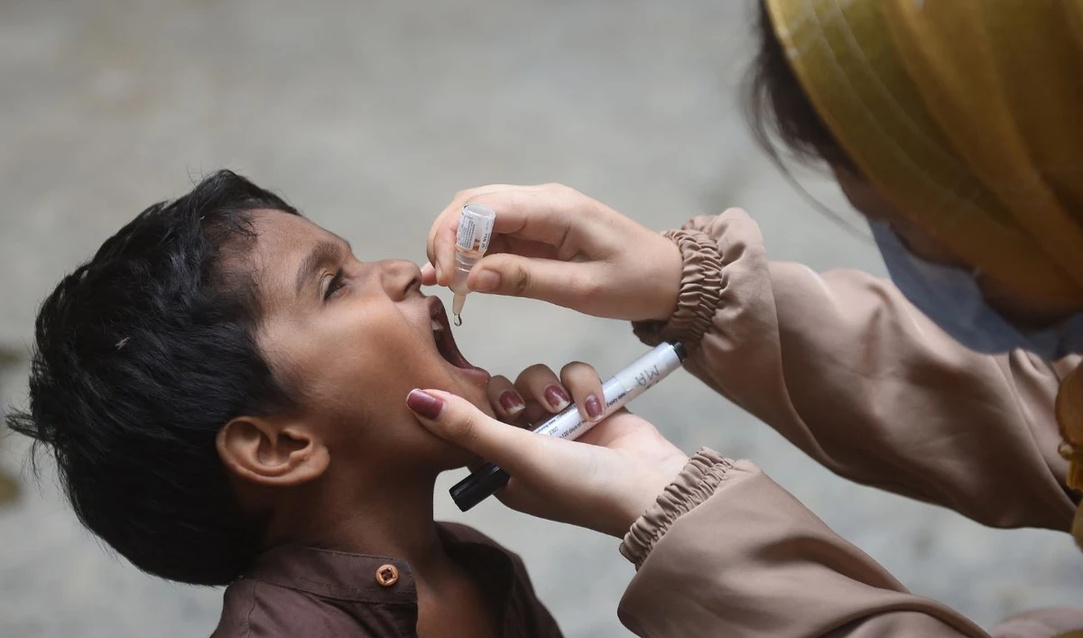 A health worker administers polio drops to a child during a door-to-door vaccination campaign in Karachi on August 7, 2023. (AFP/File)