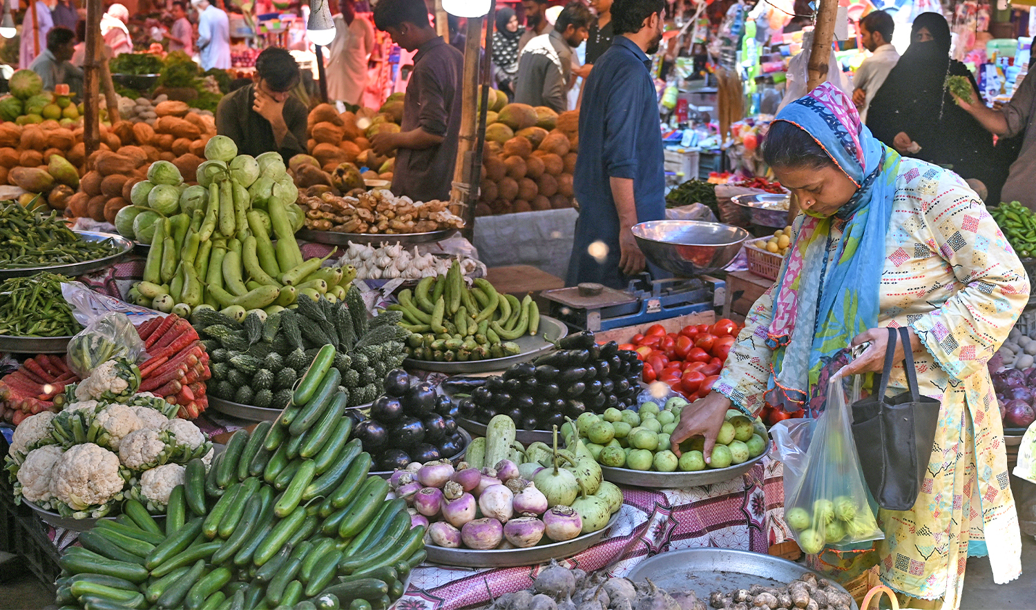 A woman buys vegetables from a stall in Karachi on September 26, 2024. (AFP/File)