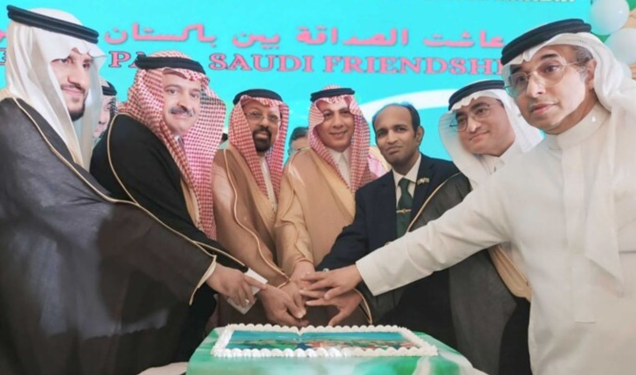 A group photo of Pakistani and Saudi officials cutting a cake at a joint event organized by the Consulate General of Pakistan to celebrate the national days of Saudi Arabia and Pakistan in Jeddah. (Photo courtesy: Pakistan embassy in Saudi Arabia)