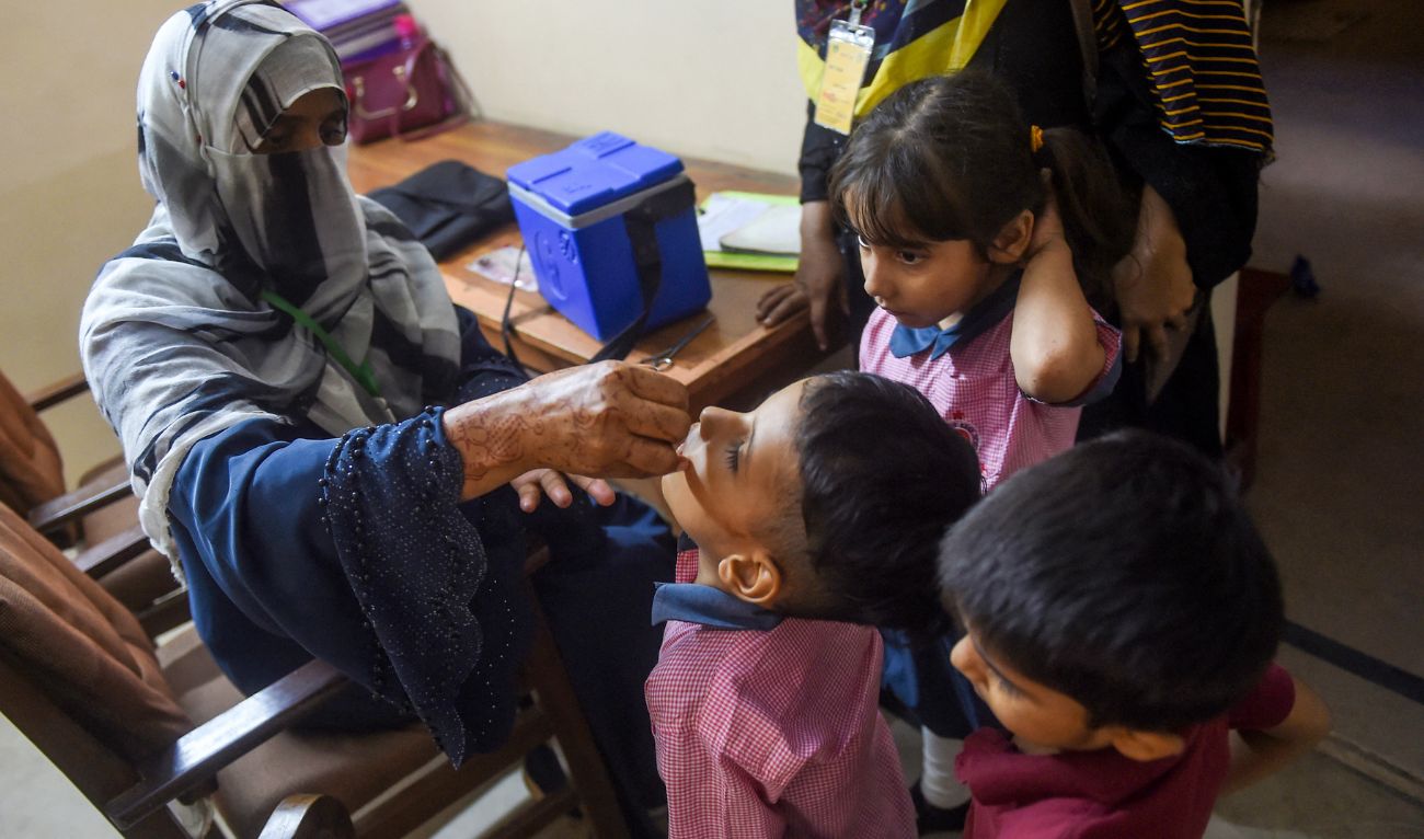 A health worker administers polio drops to a child during a door-to-door vaccination campaign in Karachi on October 2, 2023. (AFP/File)