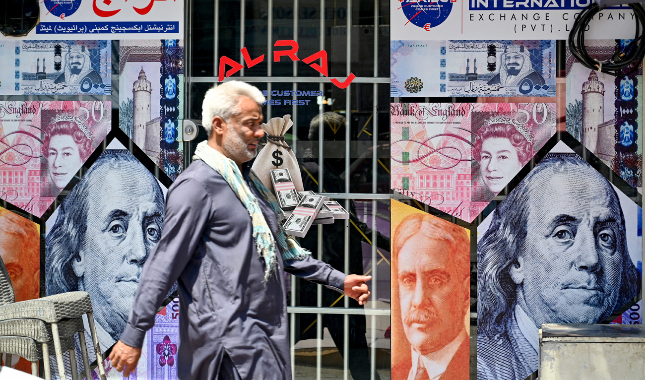 A man walks past a currency exchange shop in Rawalpindi on June 12, 2024. (AFP/File)