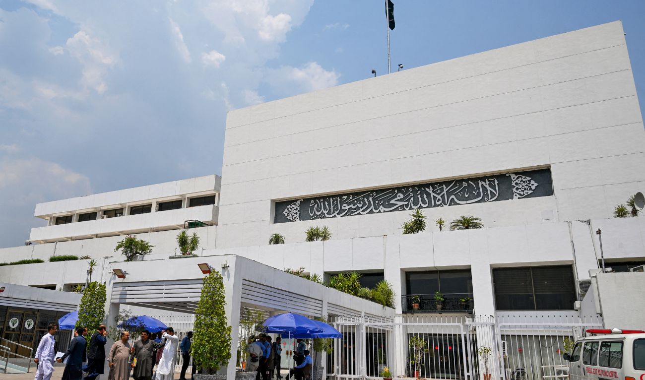 People stand outside the Parliament house during a budget session in Islamabad on June 26, 2024. (AFP/File)