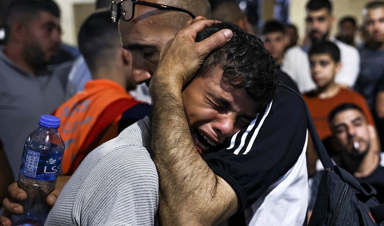 A boy cries at a hospital morgue after four men were killed in a vehicle by Israeli special forces in Nablus, in the occupied West Bank, on October 9, 2024. (AFP)