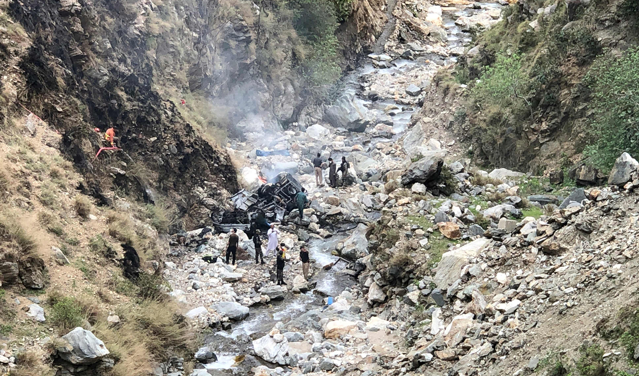 In this file photo, taken on March 26, 2024, security officials inspect the wreckage of a vehicle which was carrying Chinese nationals that plunged into a deep ravine off the mountainous Karakoram Highway after a suicide attack near Besham city in the Shangla district of Khyber Pakhtunkhwa province. (AFP/File)