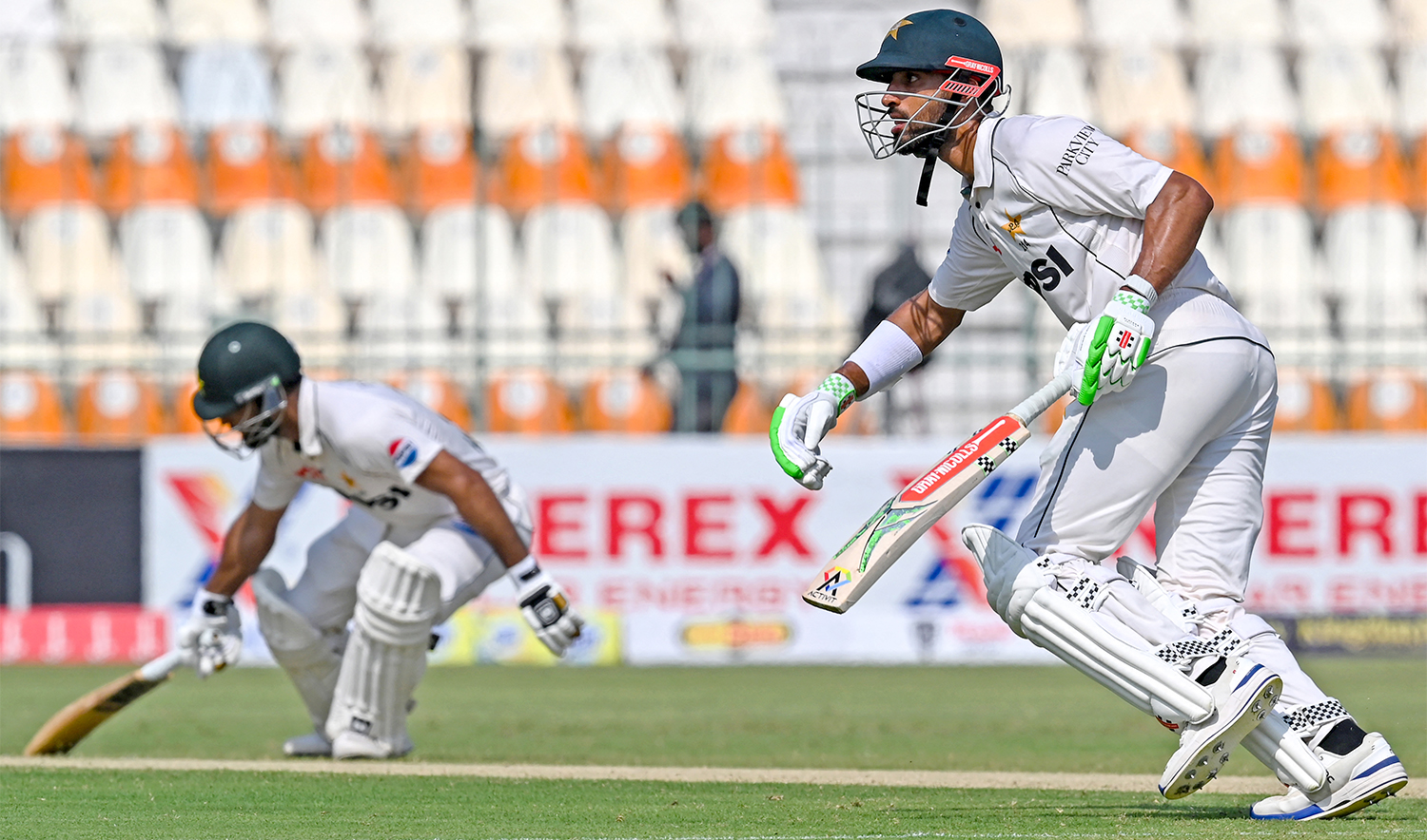 Pakistan's captain Shan Masood (R) and Abdullah Shafique run between the wickets during the first day of the first Test cricket match between Pakistan and England, at the Multan Cricket Stadium in Multan on October 7, 2024. (AFP)