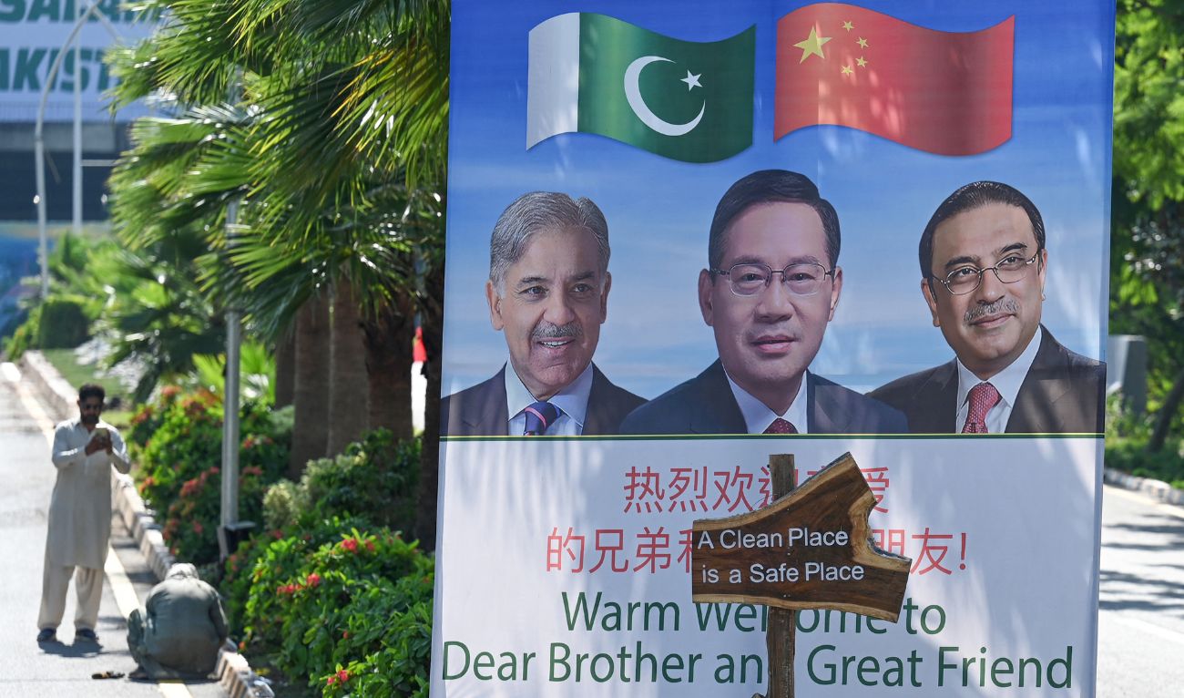Labourers work near a billboard featuring images of China's Premier Li Qiang (C), Pakistan's Prime Minister Shehbaz Sharif and President Asif Ali Zardari (R) at a closed Red Zone near the venue of Shanghai Cooperation Organisation (SCO) summit in Islamabad on October 13, 2024. (AFP)