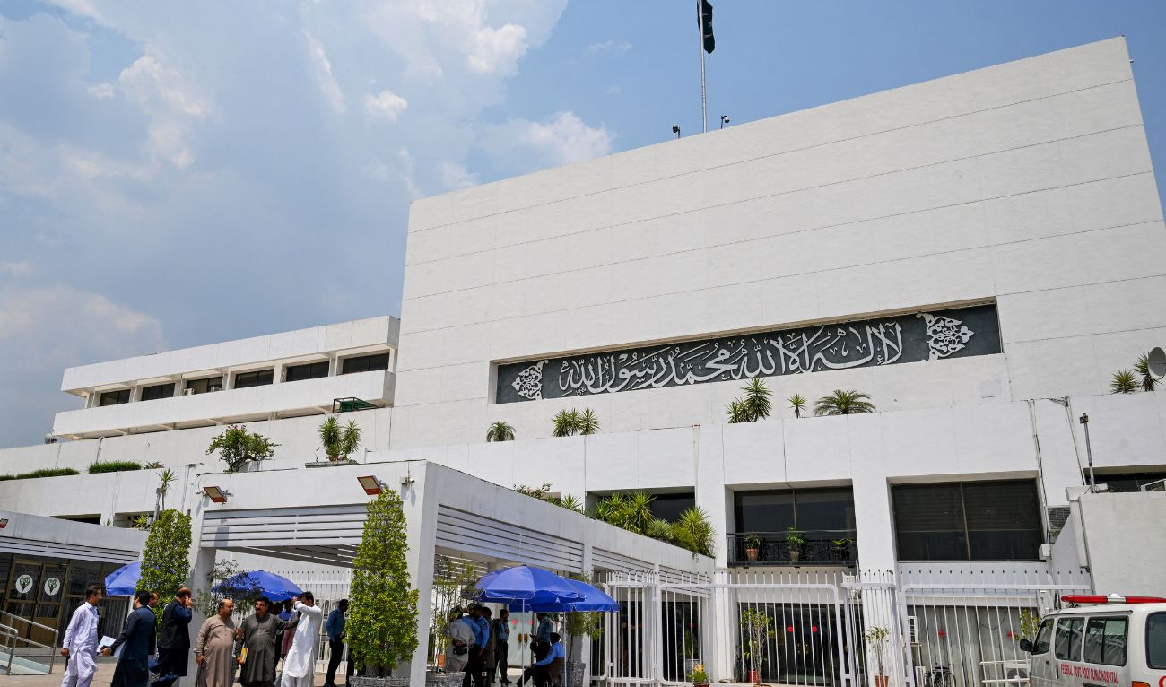 People stand outside the Parliament house during a budget session in Islamabad on June 26, 2024. (AFP/File)