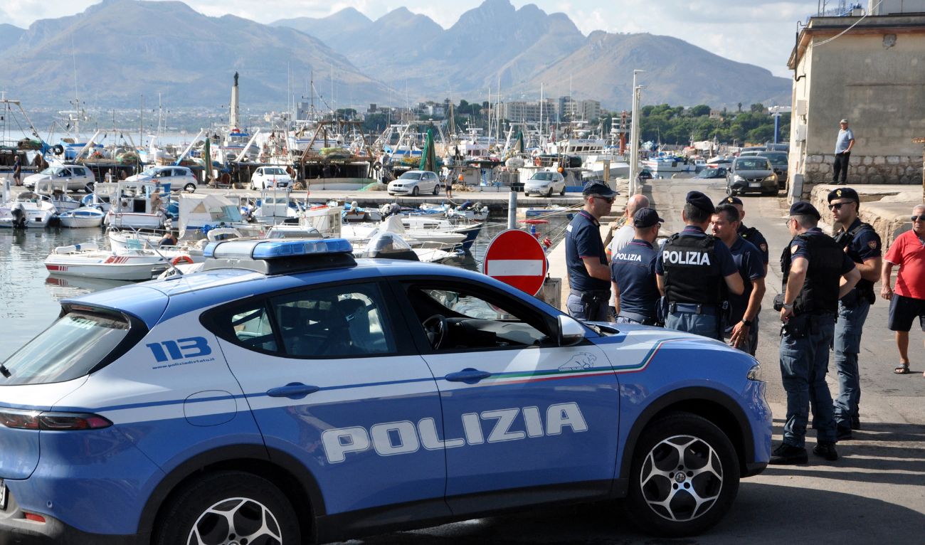 Italian police officers stand at the port as the search continues for six passengers missing from a sailboat that sank off the coast of Porticello, north-western Sicily, on 19 August 2024. (AFP/File)