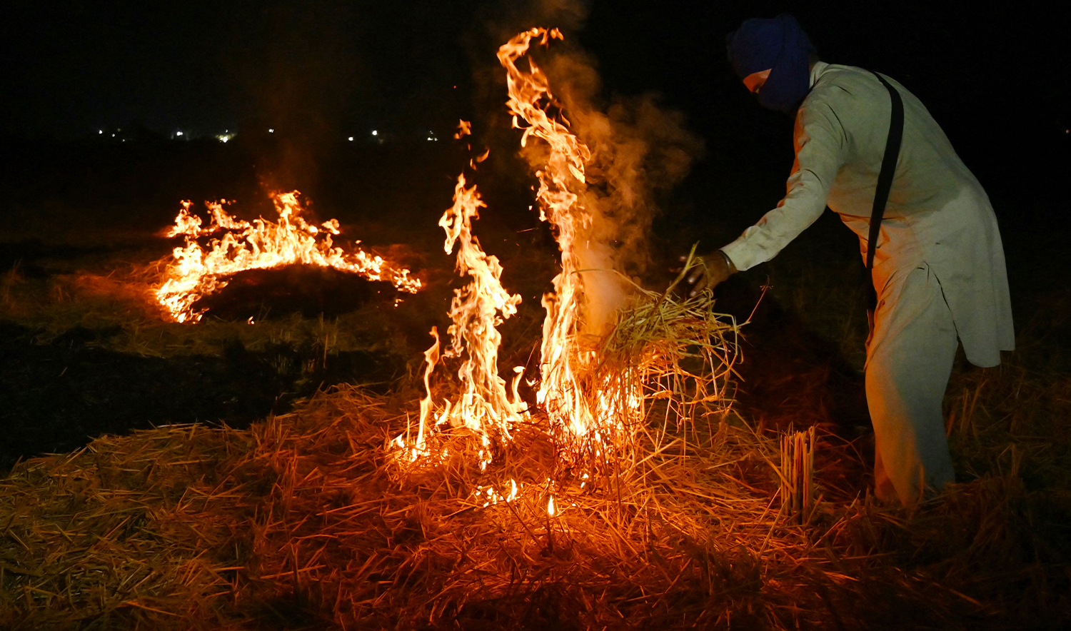 A farmer burns straw stubble after a harvest, at a paddy field on the outskirts of Amritsar on October 21, 2024. (AFP)