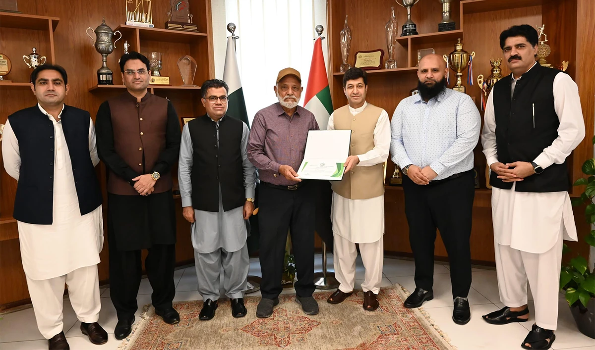 Expat Muhammad Siddique Baksh (center) receives an appreciation certificate from Pakistan’s consulate general in the UAE in Dubai, UAE, on October 2, 2024, for having not a single driving violation in 55 years. (APP)