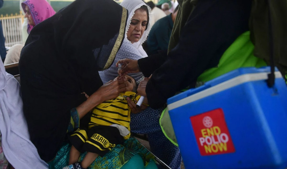 A health worker administers polio vaccine drops to a child at a railway station during a vaccination campaign in Karachi on March 14, 2023. (AFP/File)