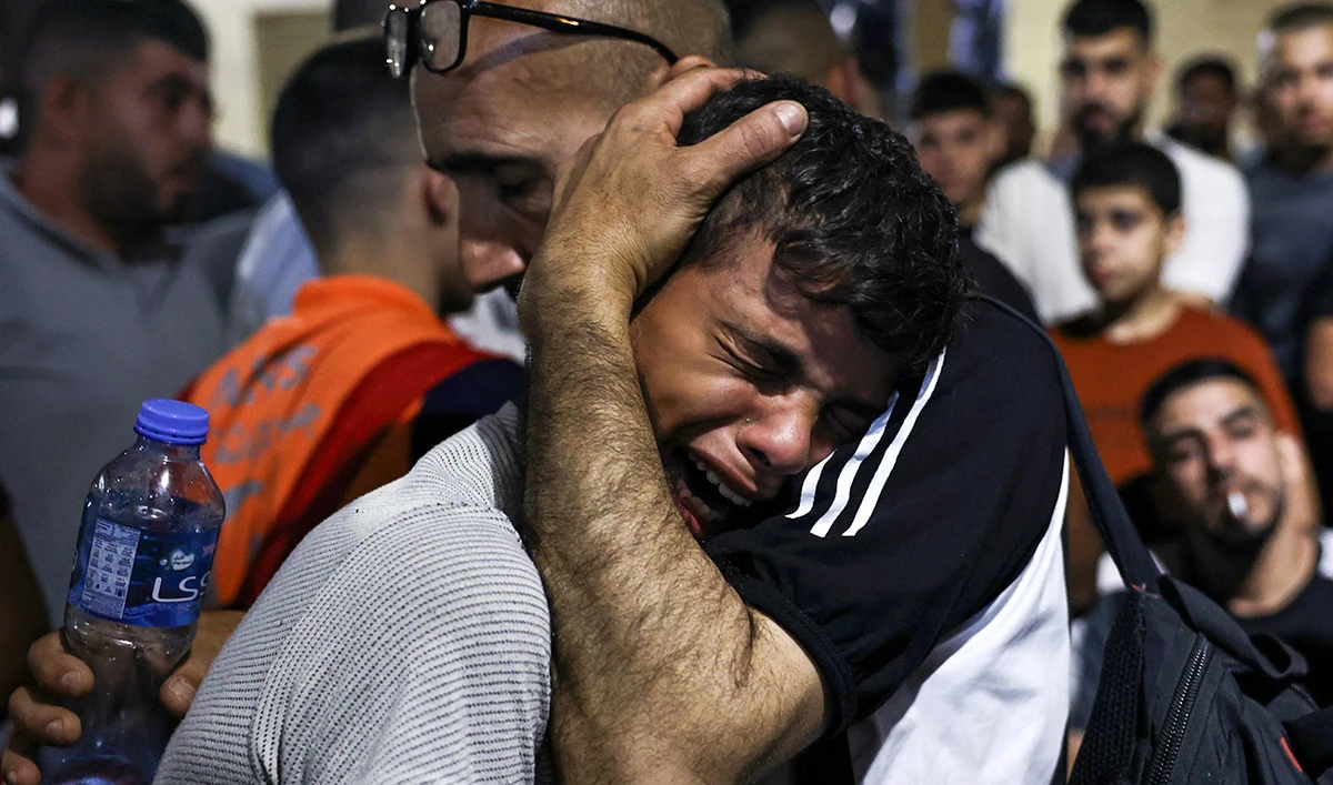 A boy cries at a hospital morgue after four men were killed in a vehicle by Israeli special forces in Nablus, in the occupied West Bank, on October 9, 2024. (AFP)