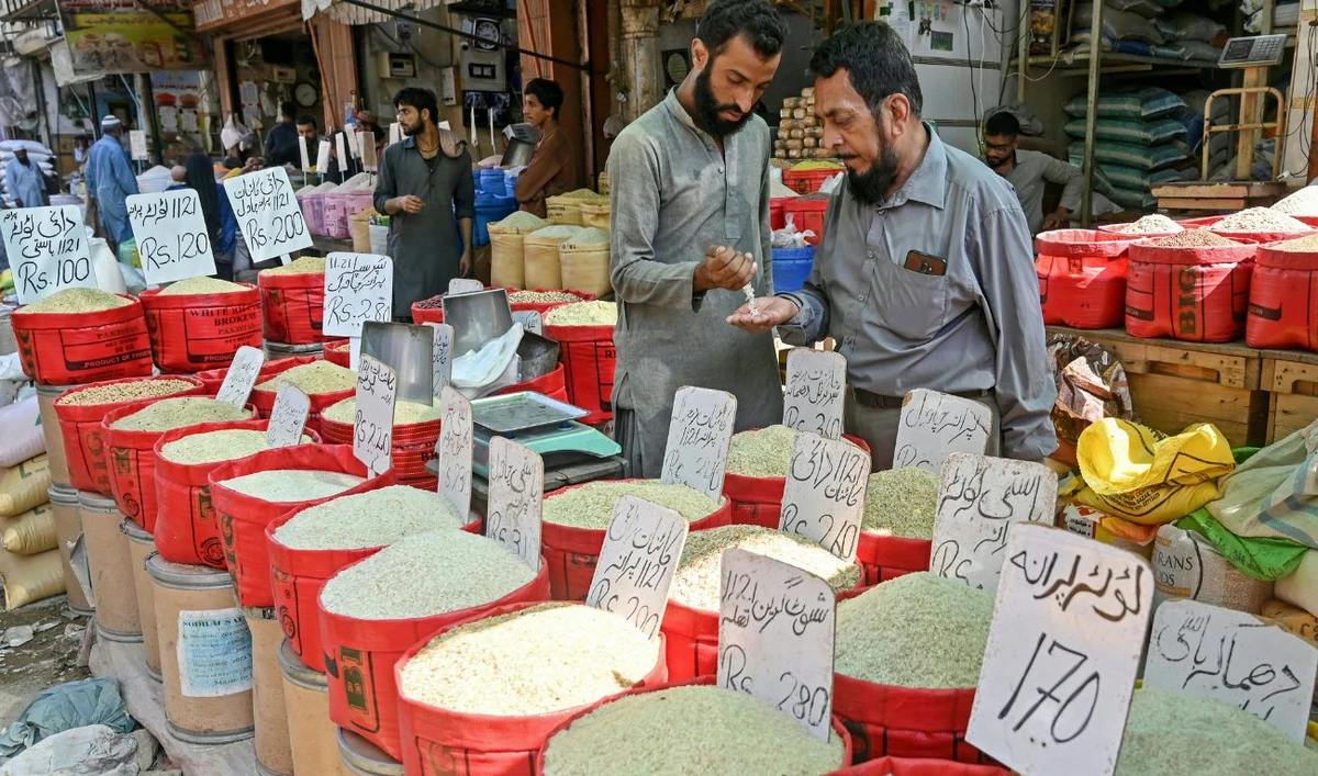 Men check quality of rice at a grocery shop in Karachi on September 26, 2024. (AFP/ File)