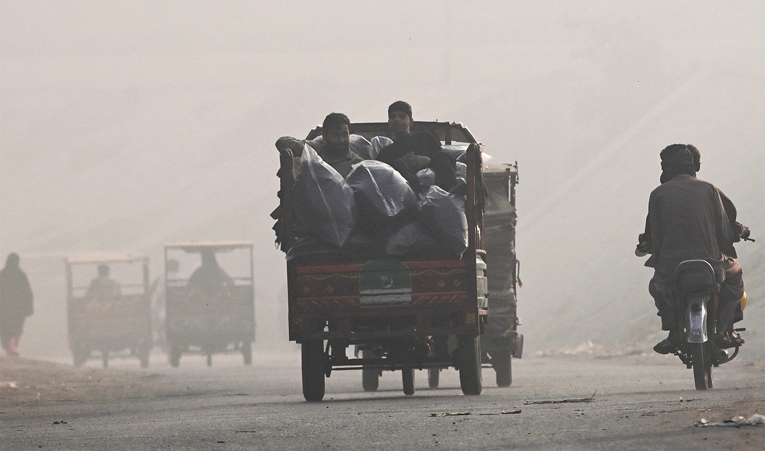 Commuters make their way amid smog in Lahore on November 2, 2024. (AFP)