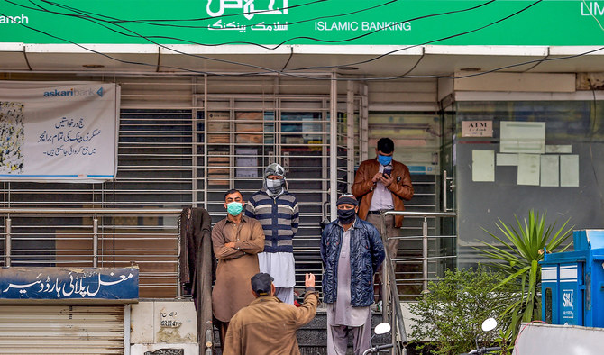 People await outside a bank in Islamabad, Pakistan, on March 24, 2020. (AFP/File)